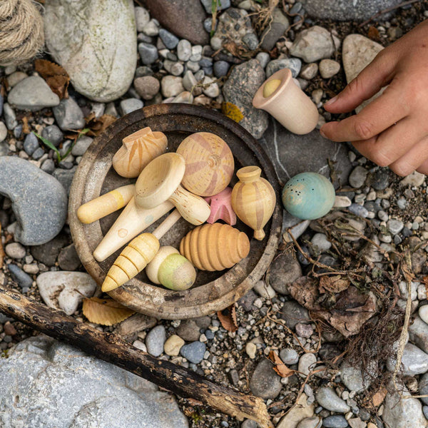 Children playing with grapat loose parts on a beach.