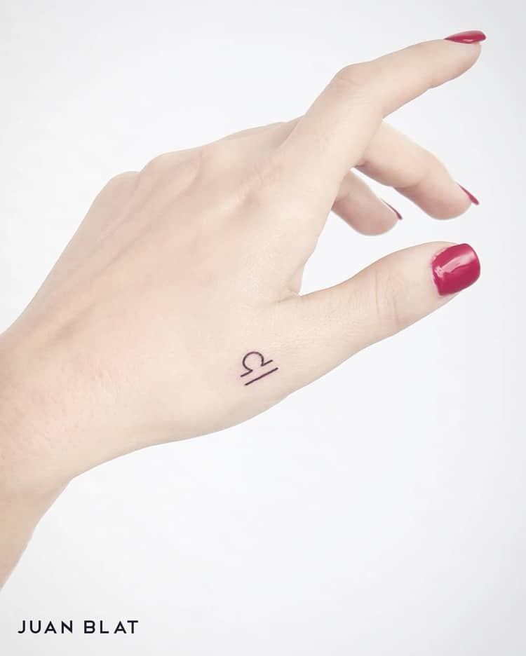 Libra micro-tattoo on hand