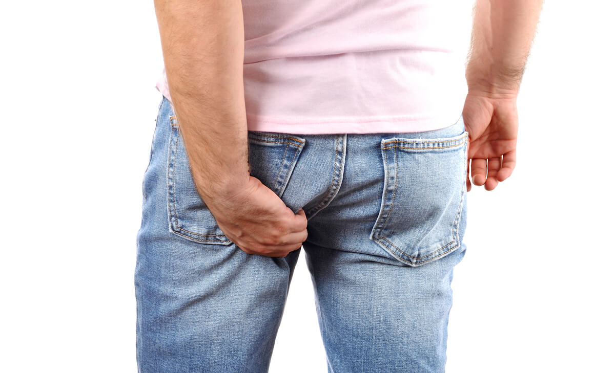Man itchy his butthole through his jeans