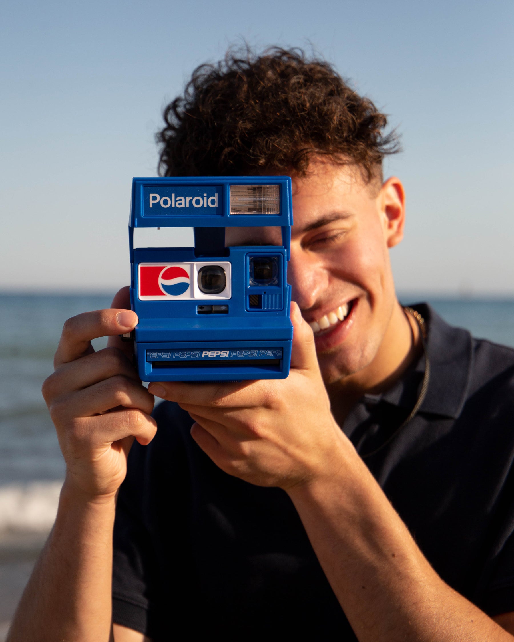 young man using pepsi polaroid