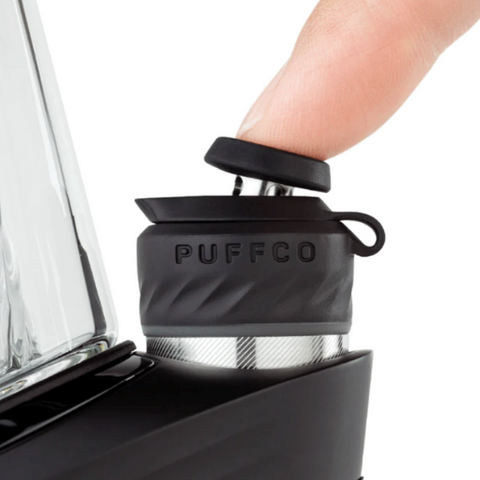 A finger pressing the Carb Cap of the Puffco Peak Pro product.