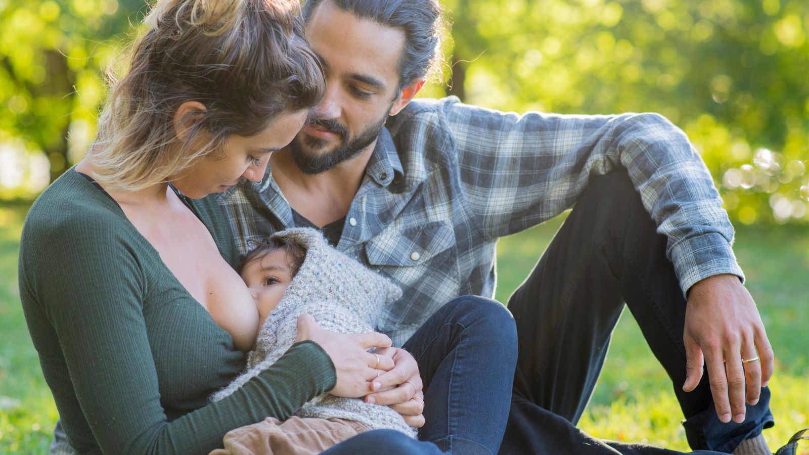 maman donnant le sein à son enfant pendant que son partenaire la soutien dans cet acte