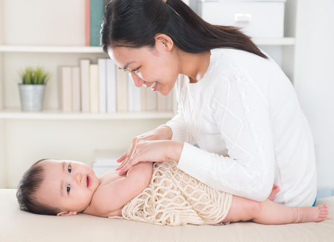 Mom massaging baby.