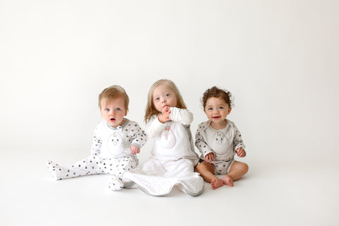 Three babies in Zen Sleepwear sitting next to each other.