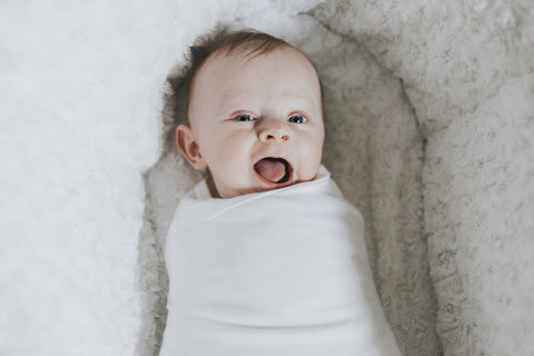 Baby dressed in sleep swaddle.