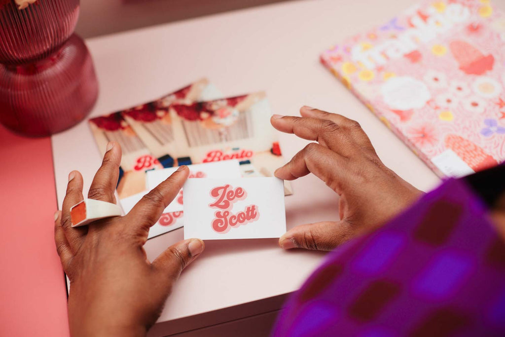 Women holding Zee Scott business cards