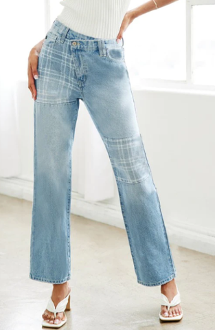 Model wearing mid-rise light wash jeans with cropped flair legs. Jeans have been lightened to create a vertical pinstriping effect.