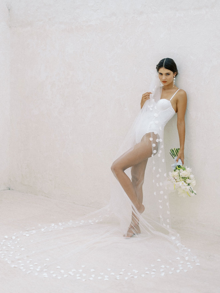 A bride wearing a long floral wedding veil