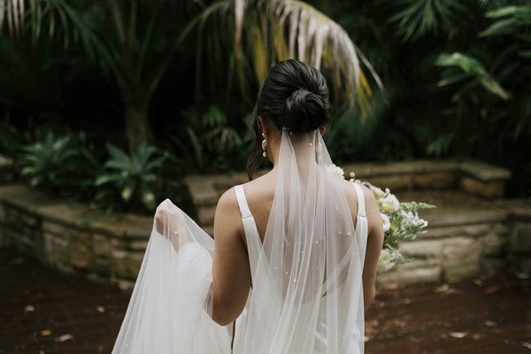 Bride wearing a long pearl veil under the hair bun