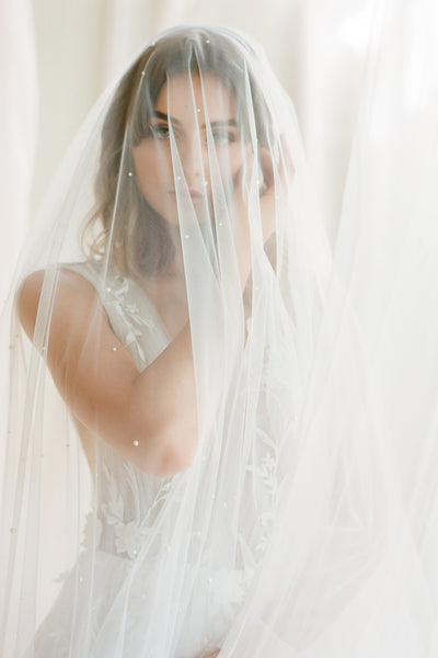 A bride wearing a pearl veil over the face