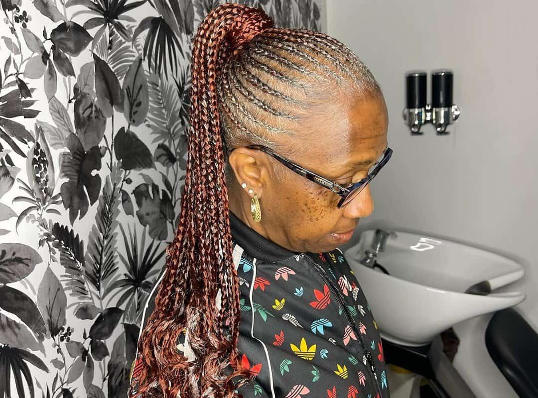 woman with brown sleek braided ponytail with weave and glasses