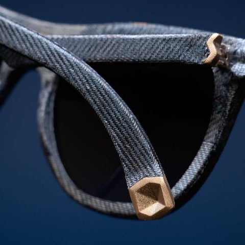 A detailed image of a pair of Mosevic handmade sunglasses showing the brass detailing