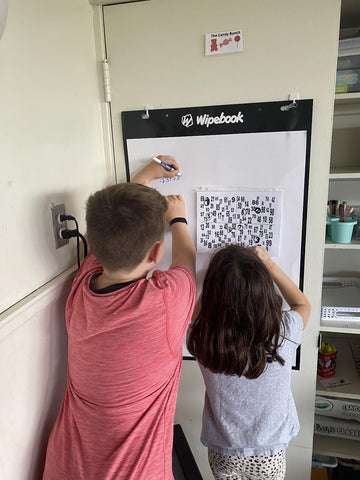 Together two of Ms. Trottier's students use Flipchart's reusable surface to solve a numeric puzzle