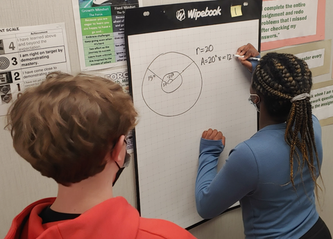 Students working on Flipcharts to solve problems