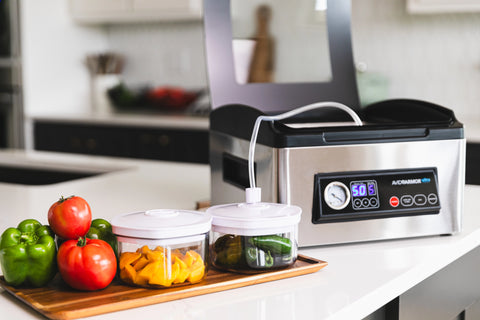 Avid Armor Ultra vacuum sealer connected to vacuum canisters for storing tomatoes, peppers, and mango slices