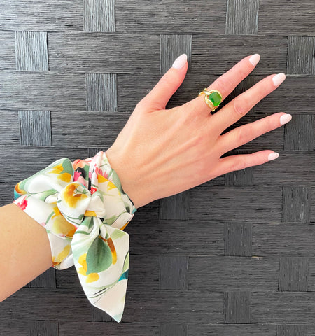 Floral skinny scarf wrapped around wrist worn as a bracelet.