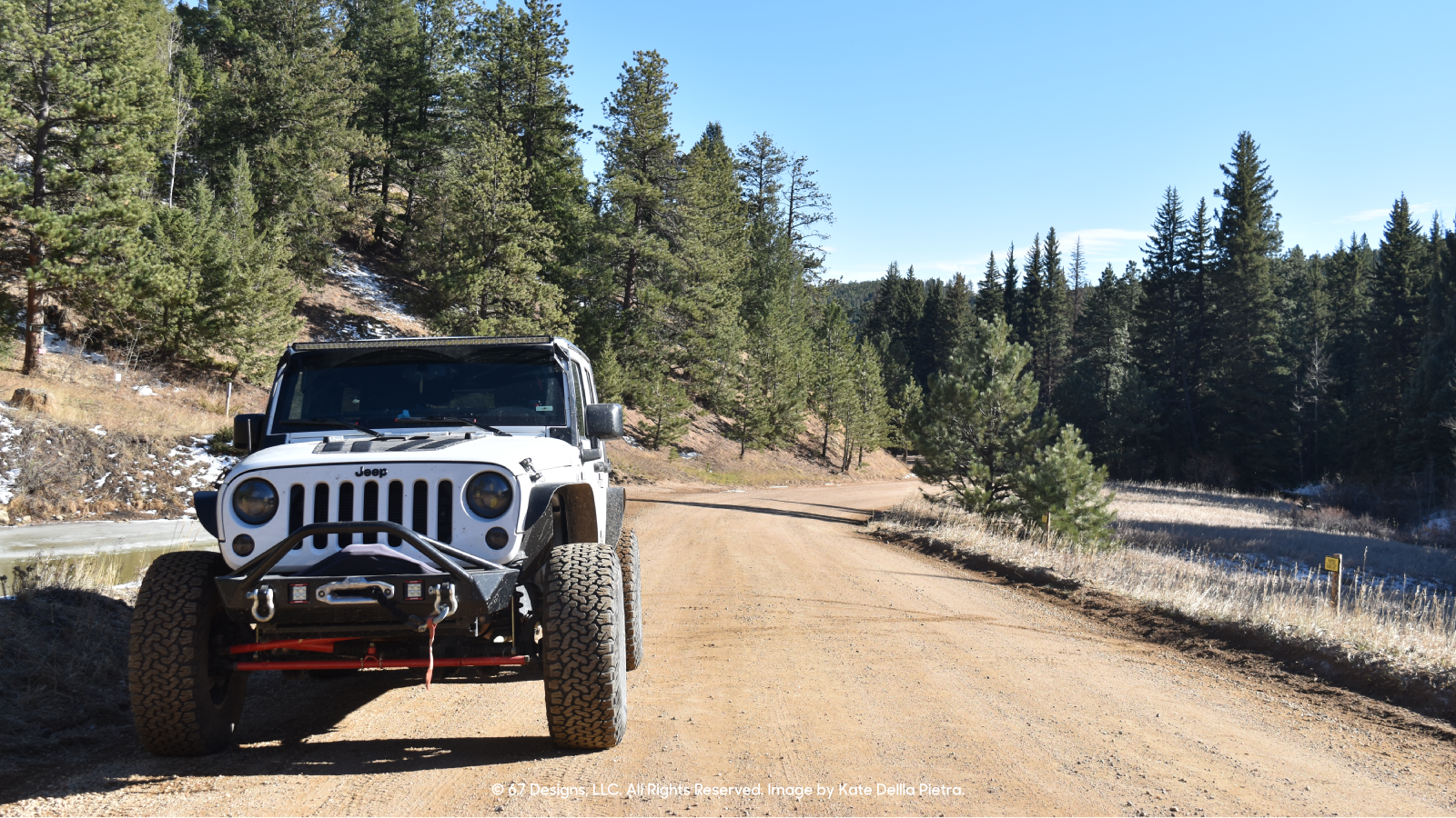 Jeep on dirt road overlooking mountains