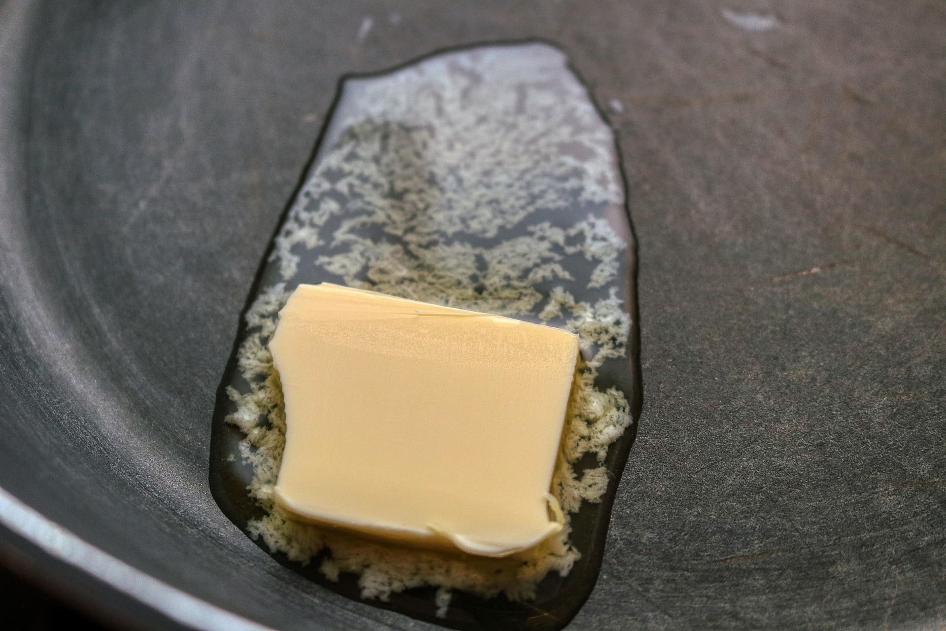 Non stick frying pan cleaning occurs as buttery blocks slide.
