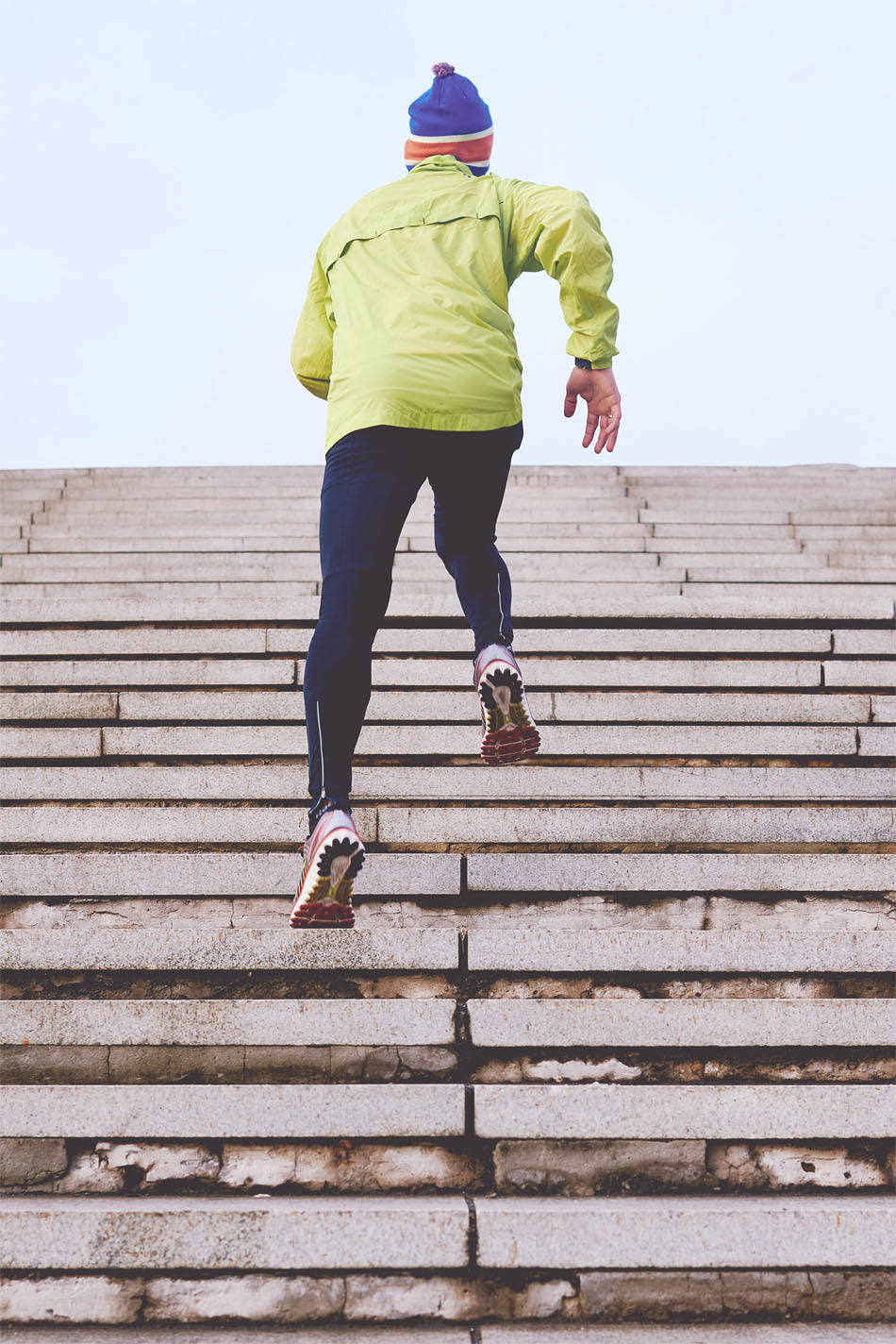 Un hombre sube corriendo las escaleras al aire libre para hacer ejercicio.