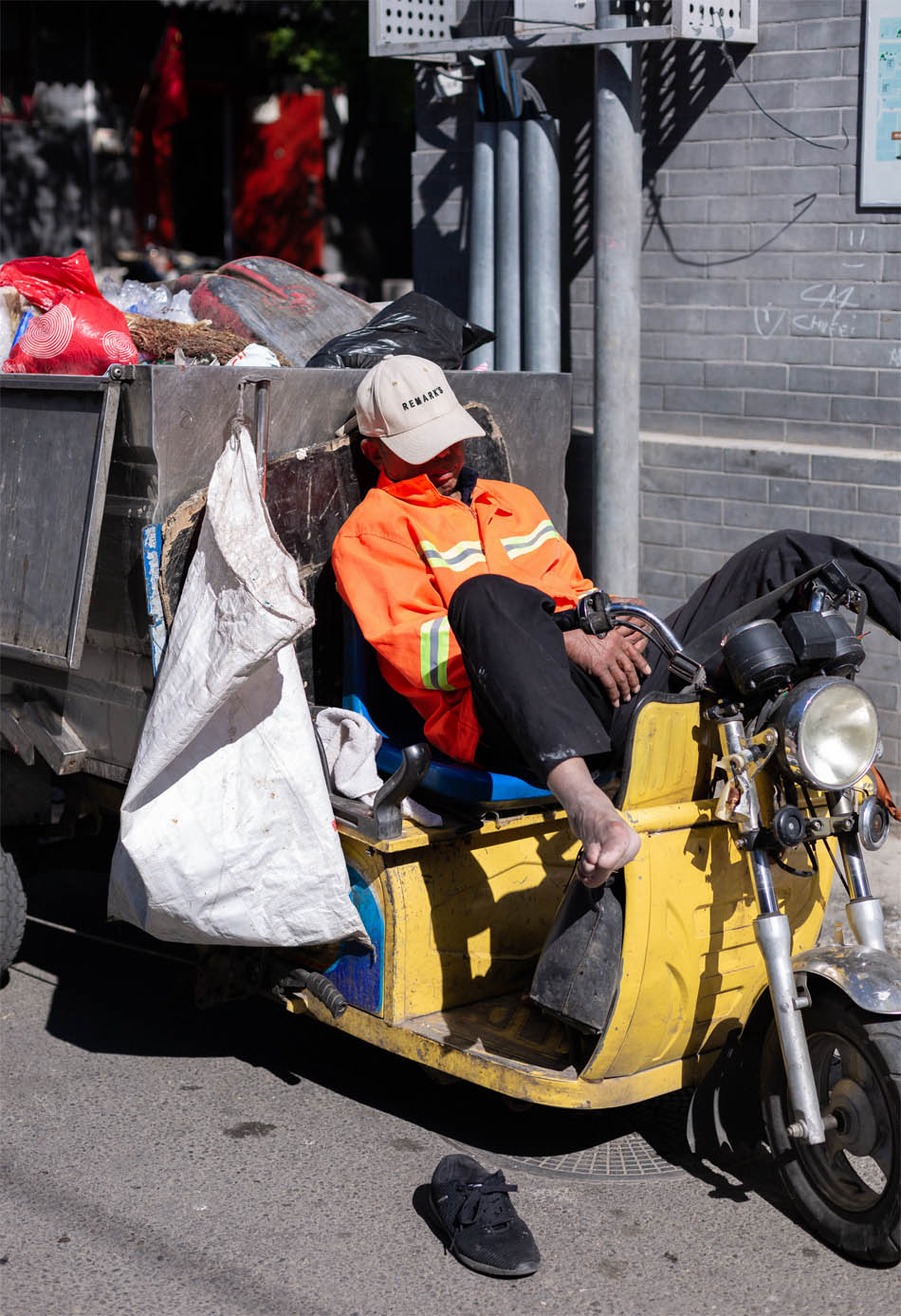 A trade professional rests with his shoes off on a motorbike.