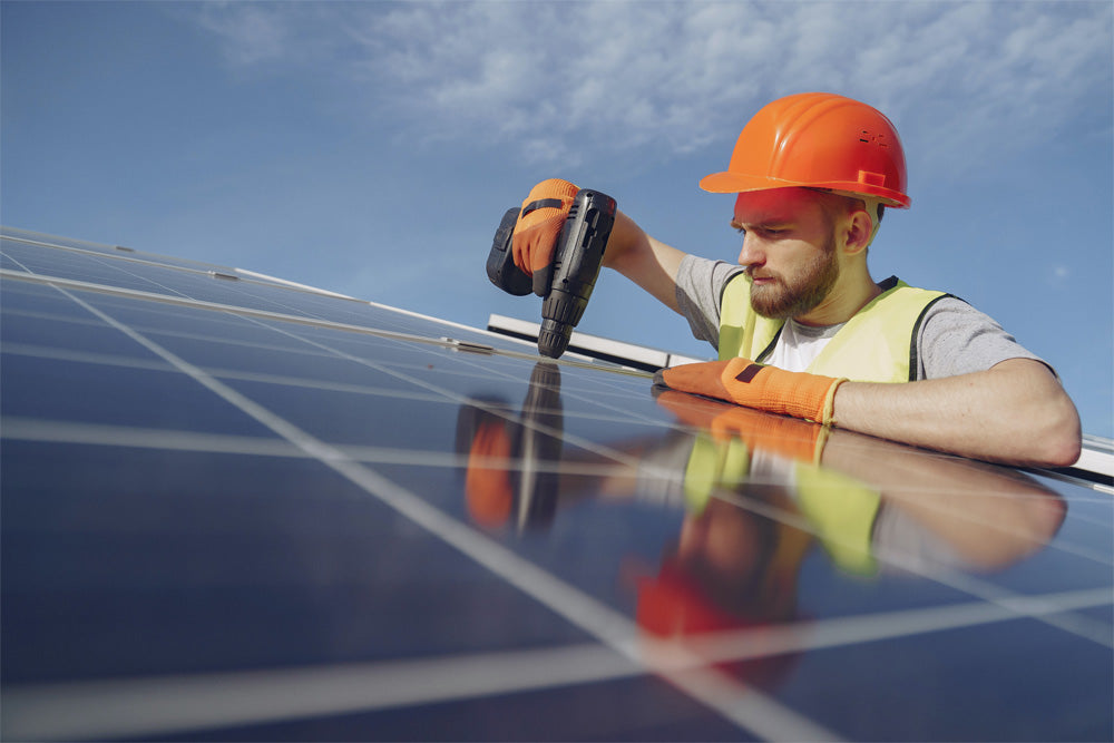 A construction worker working on a solar panel