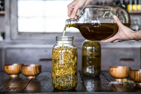 Olive Oil Poured into Jar of Herbs
