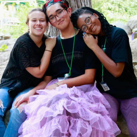 Image of 3 teenagers hugging while spending time at Brave Trails summer camp