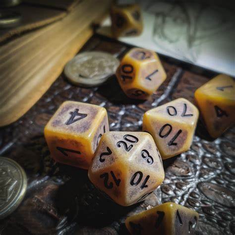 A photo of a set of brown dice with black numbers. They are set on a black surface with a coin and something wooden in the background