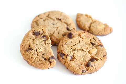 A photo of several cookies, two whole and two broken in half, against a white background