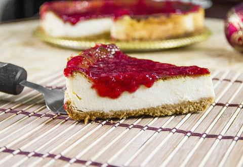 A photo of a slice of cheesecake topped with fruit on top of a wire rack