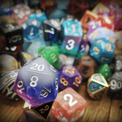 A photo of an assortment of dice, in various colors, sizes, and numbers of sides. 