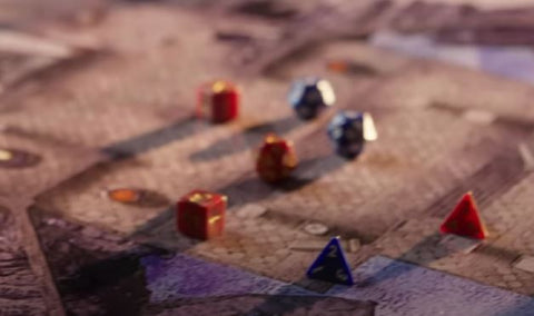 A screenshot of the youtube announcement from One D&D. It shows a set of several colored dice on a playmat