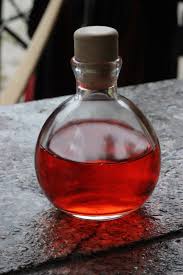 A photo of a potion bottle filled with red liquid, implied to be a love potion. 