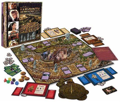 A photo of the components of Labyrinth the Board Game. The box lid is set at the back of the image, with the game board in front, with the cards, miniatures, and dice scattered around it. 