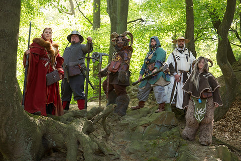 A photo of several people in fantasy character costumes in the woods, presumably preparing for a LARP