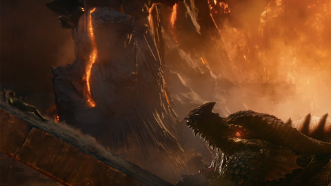 A screenshot from Dungeons and Dragons Honor Among Thieves. It shows the silhouette of a dragon and a woman sliding down an incline toward the dragon's open mouth, against the backdrop of a burning cave