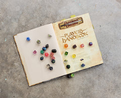 A photo of the 3.5e players handbook, open to the title page, with dice of various colors scattered across the open pages