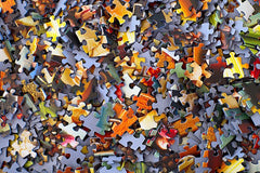 A photo of a pile of standard-cut jigsaw puzzle pieces. They are a number of different colors