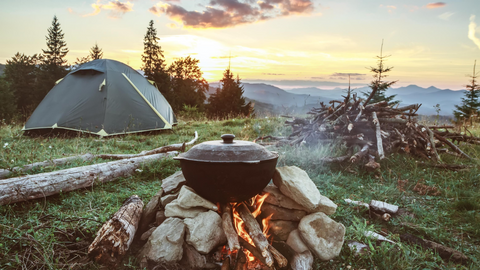 Cooking over campfire overlooking view of the mountains