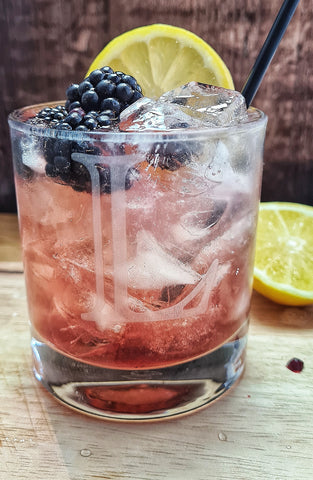 Bramble cocktail drink with blackberries and gin 