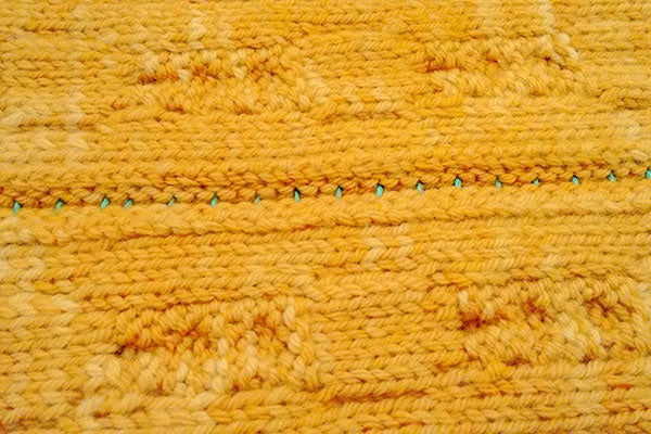 Wrong side of knit garment after basting fronts closed