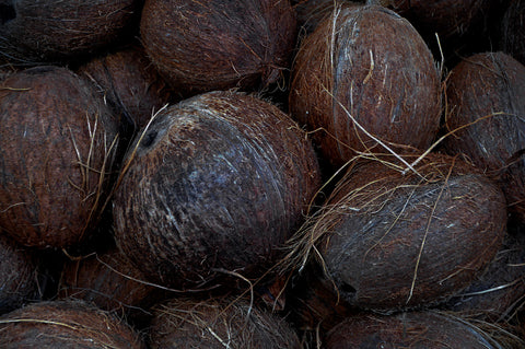 Pile of textured brown whole coconuts