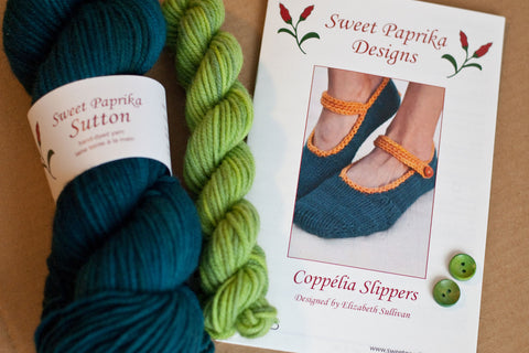 Coppélia Slippers knitting kit with yarn, pattern booklet, and wooden buttons