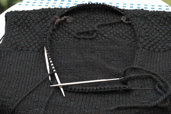 Neckline of black tunic sweater.