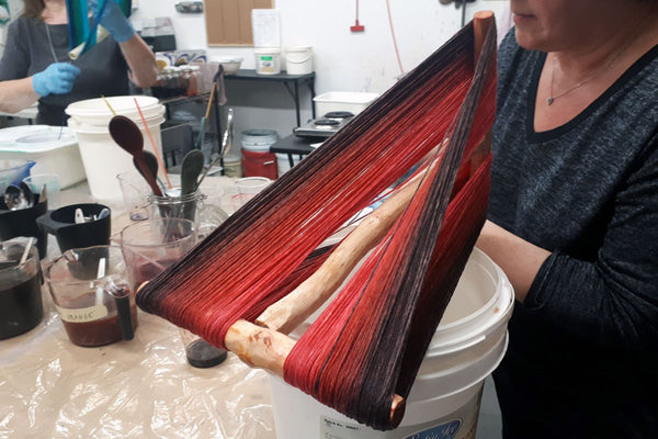 gradiant red to black yarn wrapped around a niddy-noddy