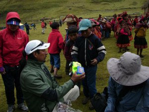 A guide from Apus Peru Willy hands out the trucks to the boys