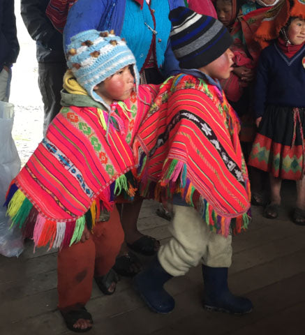 boys in red ponchos; Andean boys in regional ponchos