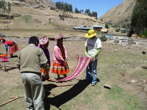 Daniel Sonqo and Urbano Huayna measure and discuss the quality of a weaving in Rumira Sondormayo.