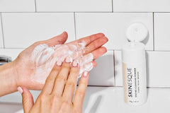 mixing Enzyme Cleansing Powder with water in palm of hand