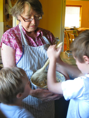 Boys stirring threepences into the Christmas Pudding batter.